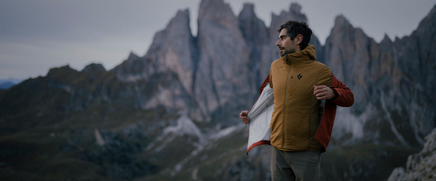 A man putting on a jacket in the Dolomites