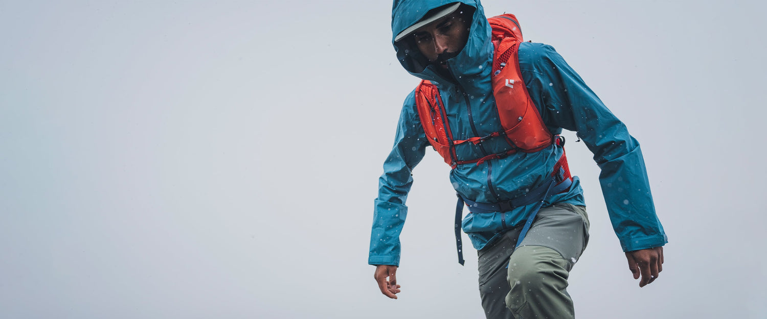 A hiker in a Fineline Shell looks on in the rain.