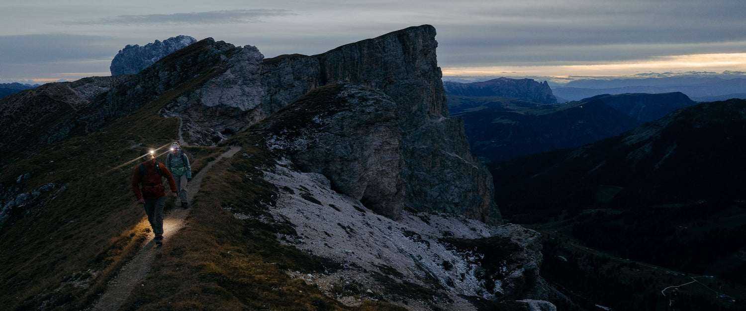 Two hikers light the up trail in the Dolomites, Italy. 