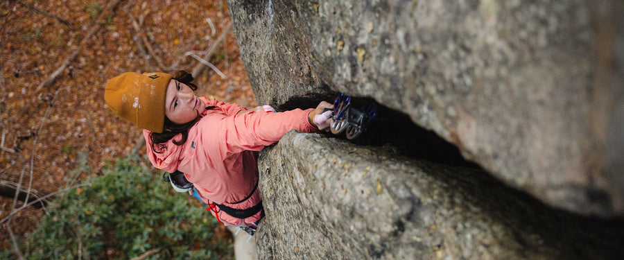 A climber places a camalot in a crack