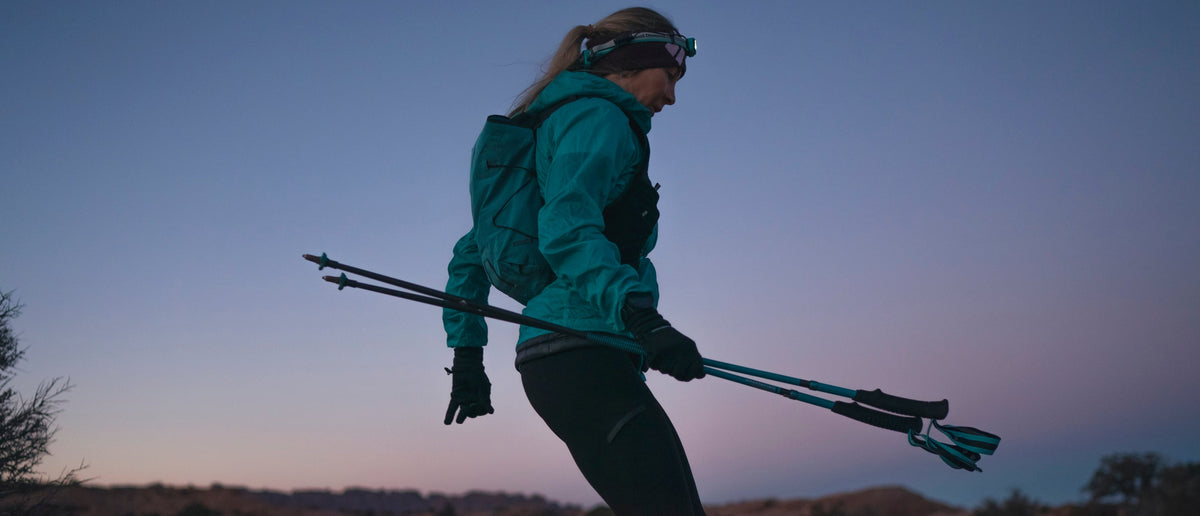 BD athlete Kelly Halpin runs through the desert at dawn carrying trekking poles. 