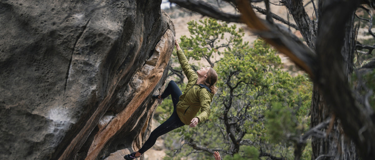 A climber in a green First Light Hoody tops out on a boulder in Joe's Valley. 