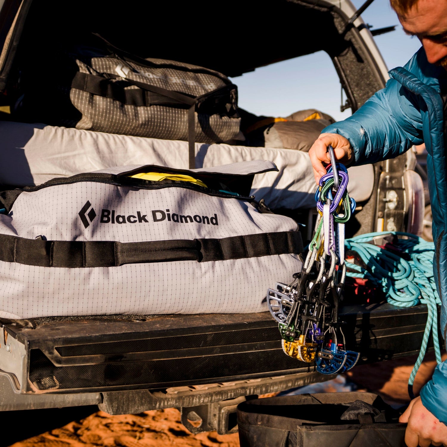 A climber adds cams to his duffel bag. 