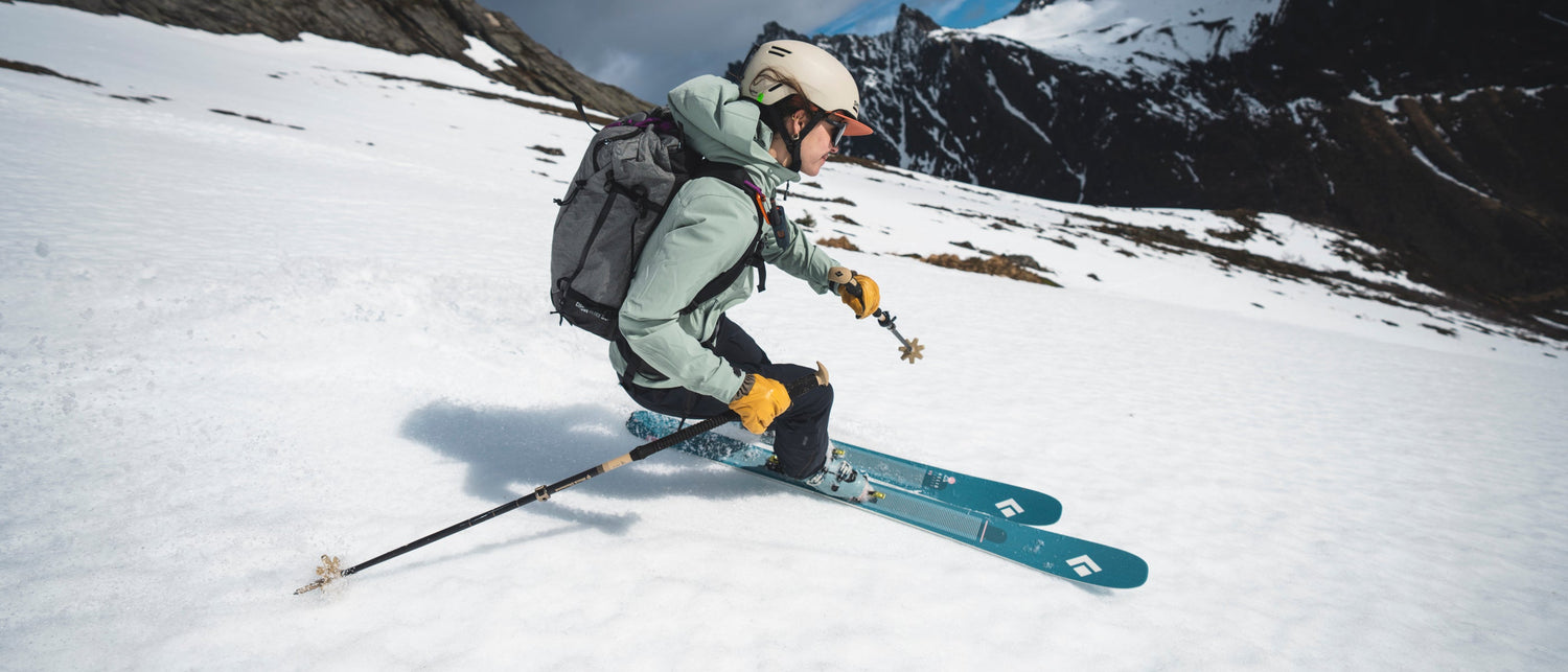 Person skiing on a snowy mountain with backpack and skis