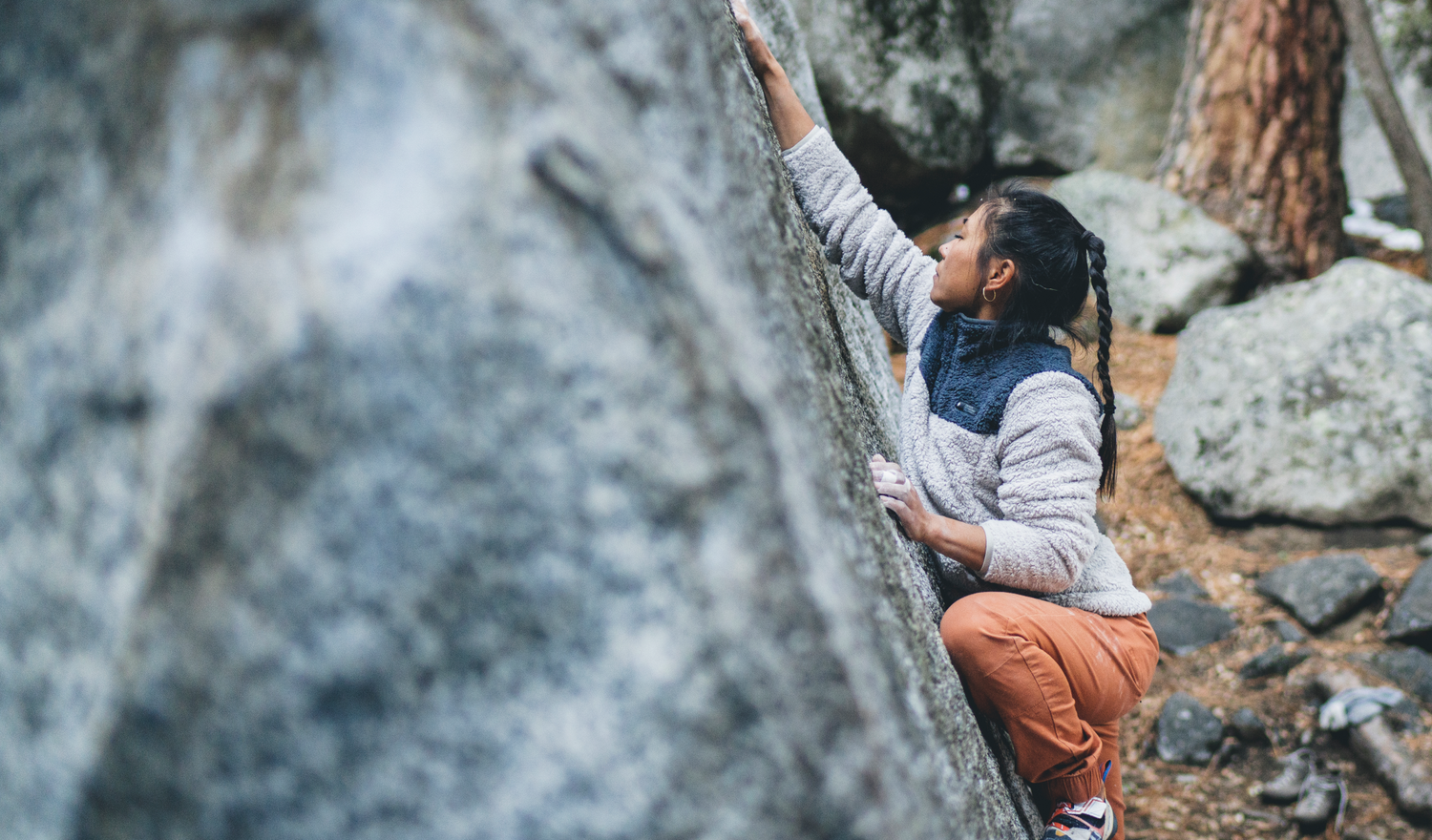 A climber reaches on a boulder in Yosemite. 