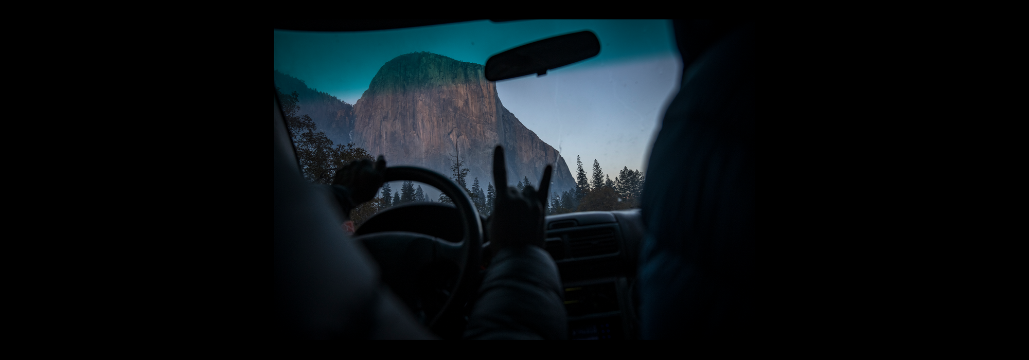 A climber views the mountains through a windshield
