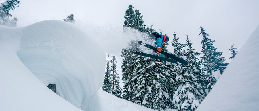 A skier jumps a snowy pillow in Impulse Skis. 