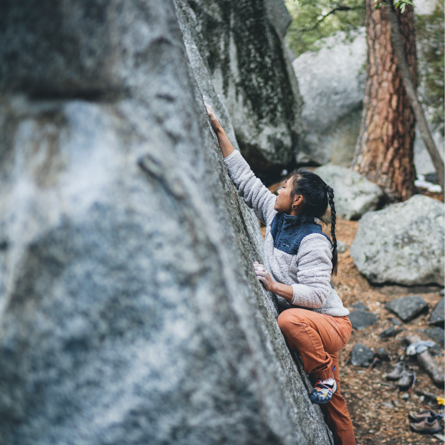 A climber reaches for a hold on a boulder in Yosemite. 