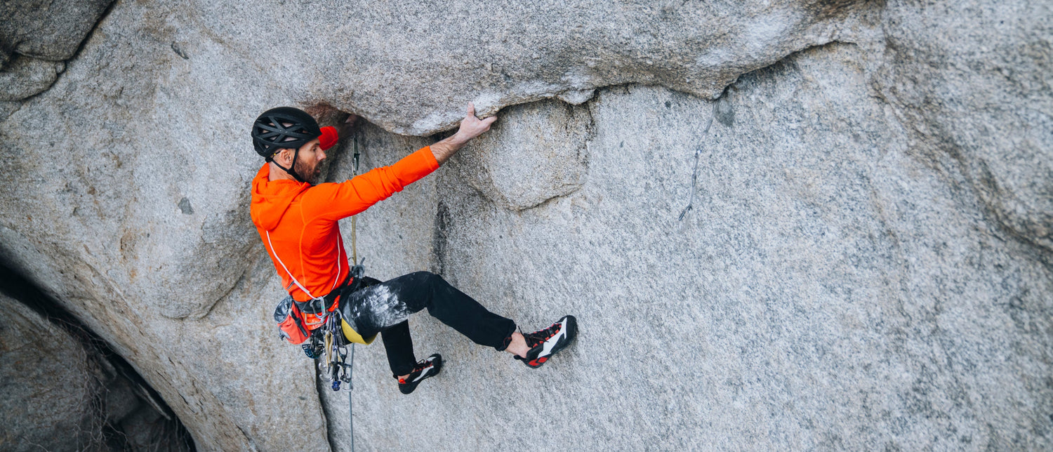 A climber wearing Aspect Pros on a granite climb. 