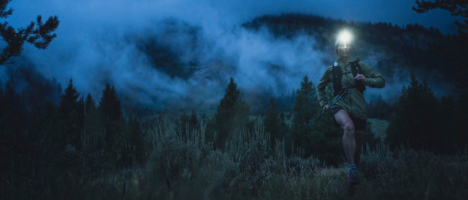 A runner wearing a headlamp on a misty morning. 