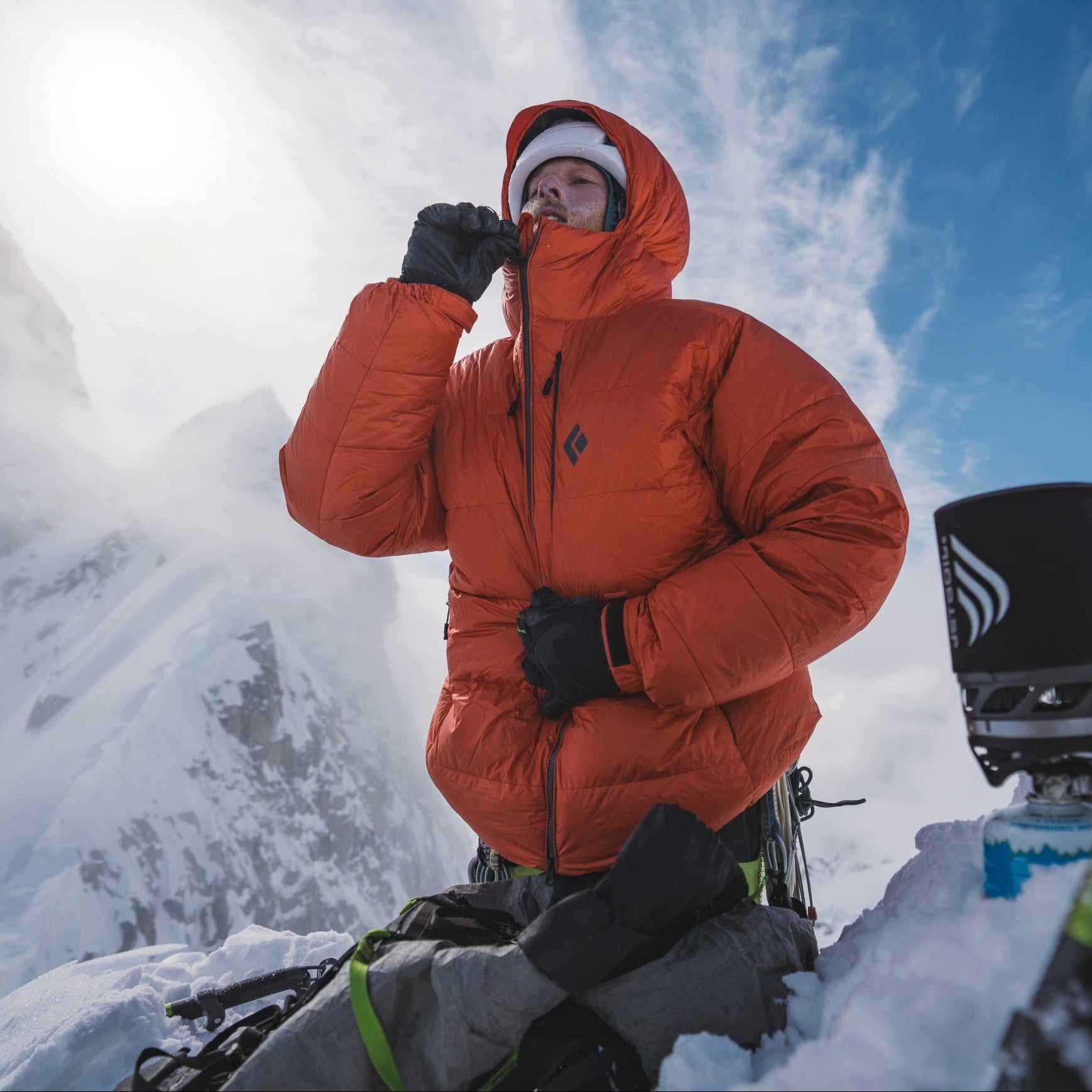 A mountaineer zips up a Mission Down Parka. 